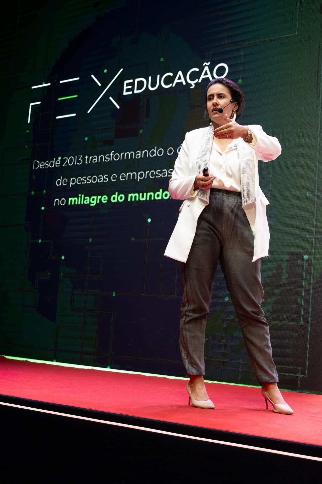 Palestrante em palco durante evento da FEX Educação